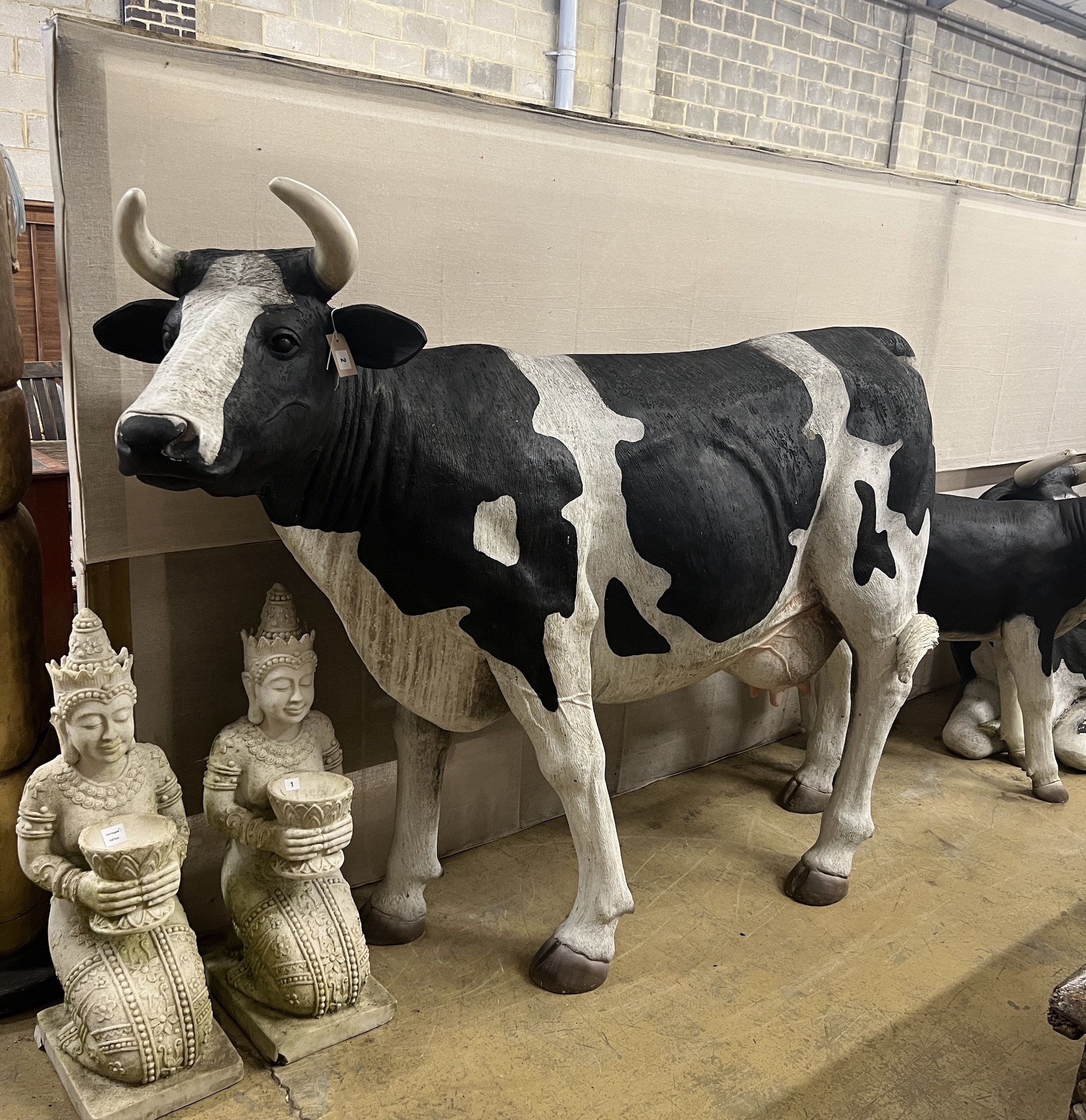 A life size composition Friesian cow garden ornament, length 205cm, height 156cm